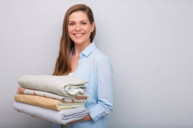 İzole edilmiş portre temizlikçisi otel servis konsepti. Elinde çarşaf tutan gülümseyen bir kadın.  