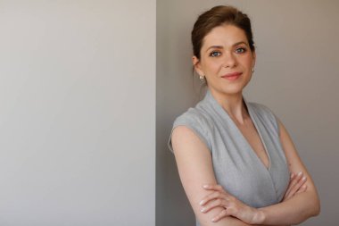 Gri elbiseli iş kadını kollarını kavuşturmuş duruyor. izole edilmiş resim.