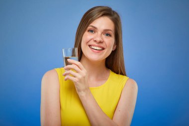 Su bardağı tutan kadın. Mavi arka planda izole edilmiş kadın portresi.