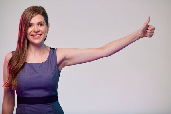 Улыбающаяся деловая женщина, показывающая большой палец. Женщина бизнесмен с длинными волосами в сером платье изолированный портрет.