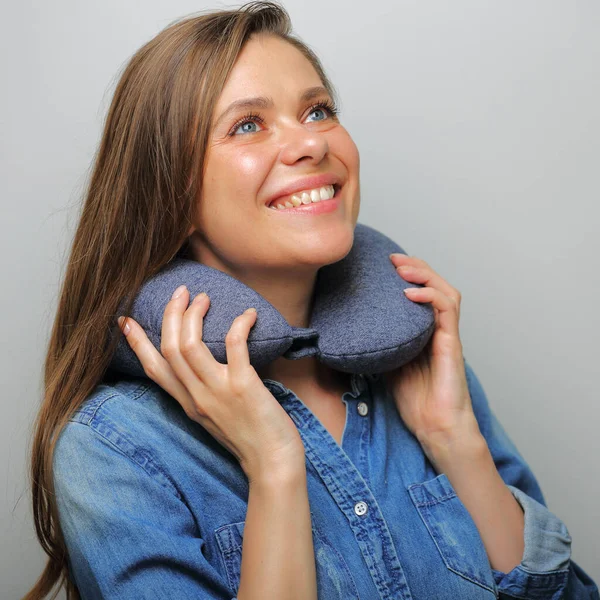 Smiling woman with travel neck pillow looking up isolated face close up portrait.