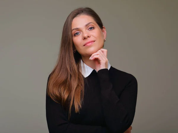 Smiling woman in black business suit touching her chin, isolated female portrait.