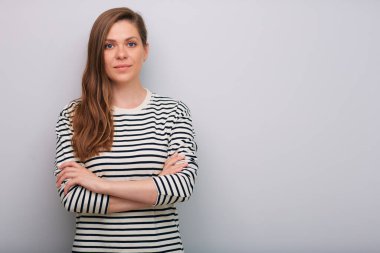 Çizgili tişörtlü, kollarını kavuşturmuş, izole edilmiş portresi olan genç bir kadın.  