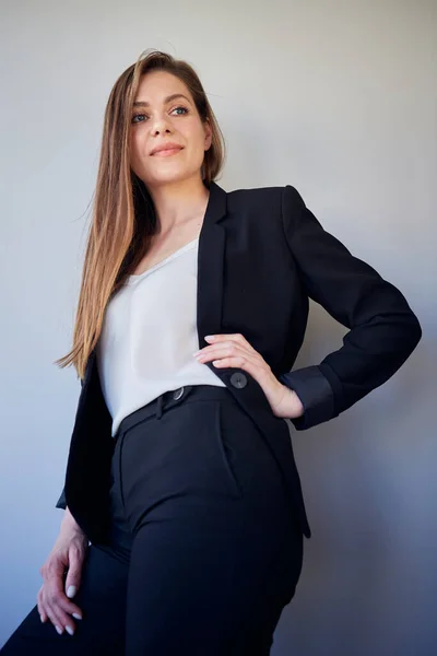 Smile woman in black business suit and white shirt keep hands on hips. isolated portrait girl looking away..