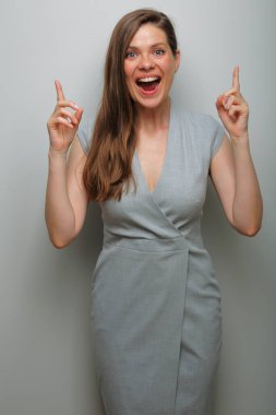 Gülümseyen kadın işaret ediyor. Gri iş elbisesi.