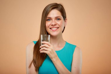 Mavi elbiseli gülümseyen kadın, sarı kahverengi arka planda izole edilmiş portre..