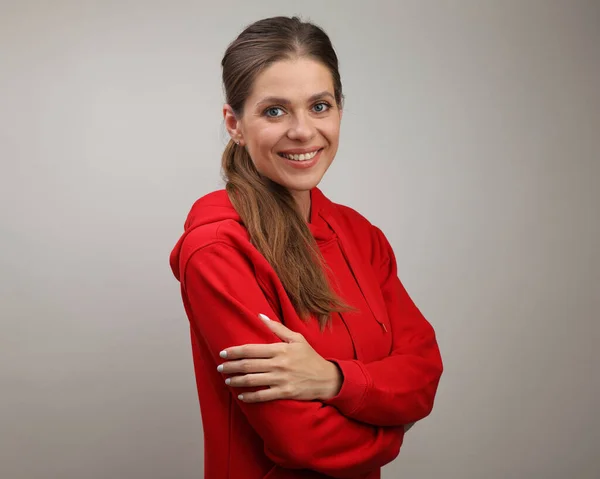 Smiling girl in red hoodie standing with crossed arms. isolated female portrait.