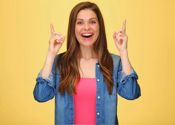 笑顔幸せな女性の肖像画で長い髪で青いデニムシャツを身に着けている黄色 指差し指アップ — ストック写真