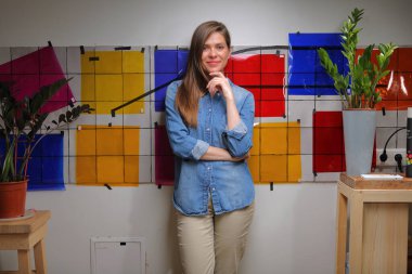 Sınıfta duvarında renk paletiyle duran tasarımcı bayan öğrenci..