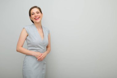 Kısa saçlı, gülümseyen bir iş kadını katlanmış elleri, izole edilmiş bir kadın stüdyo resmi, gri elbiseli genç bir iş kadını..