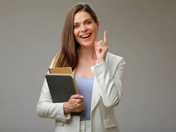 笑顔の女性教師の指を指しての孤立した肖像 白いビジネススーツを着て女性は本を保持 — ストック写真