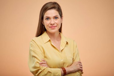 Sarı gömlekli gülümseyen genç bayan katlanmış ellerle izole edilmiş portreler..