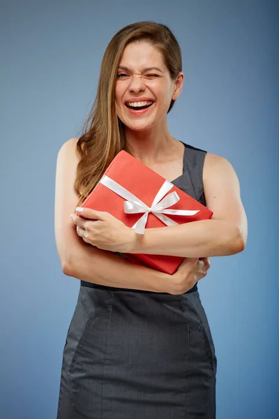 Winking business woman with red gift studio isolated portrait on blue.