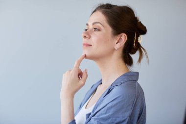 Gülümseyen kadın çeneye dokunuyor ve başka tarafa bakıyor.. 