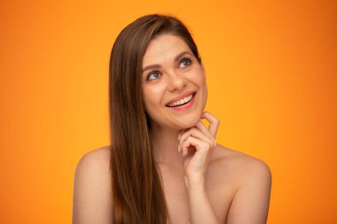 Gülümseyen mutlu kadın yukarı bakıyor ve çenesine dokunuyor. Uzun saçlı ve çıplak omuzlu bir kız. İzole edilmiş kadın portresi..