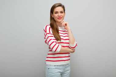 Yüzüne dokunan gülümseyen bir kadın stüdyo resmi, kırmızı çizgili beyaz kazaklı bir kız..