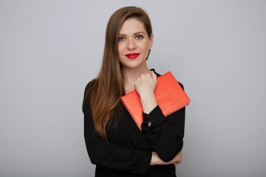 Elinde kırmızı kitap tutan siyah elbiseli öğretmen kadın. Yetişkin bir öğrencinin izole edilmiş portresi.