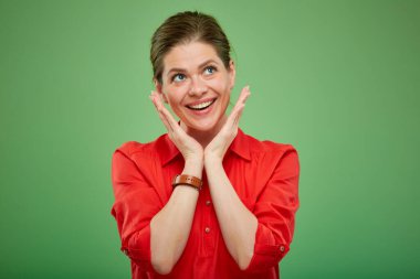 Kırmızılı mutlu kadın yukarı bakıyor, yeşilde soyutlanmış.