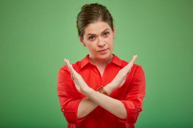 Tecrit edilmiş ciddi bir kadın, dur hareketi yapıyor, yeşil arka planda bir portre..