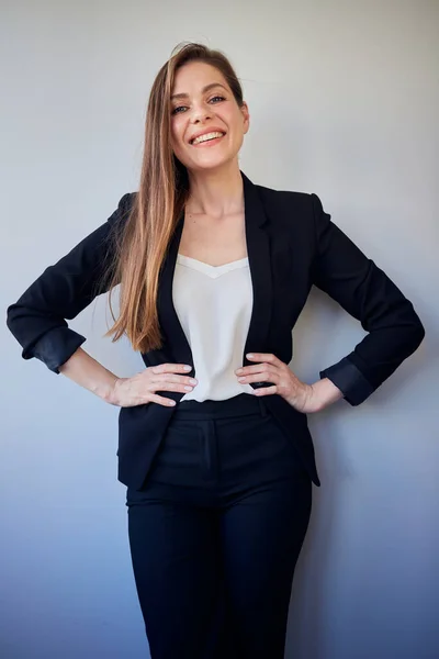 Woman in black business suit and white shirt with her hands on her hips. isolated portrait.