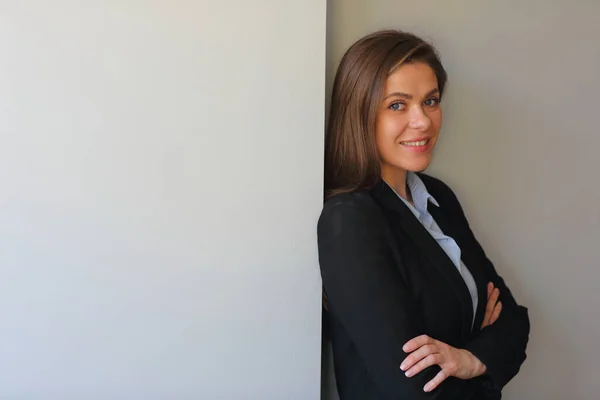 Smiling woman in business suit portrait with crossed arms.