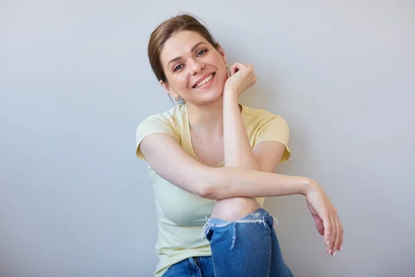 Smiling Woman Sits Her Back Wall Dressed Casual Clothes Isolated Stock Image