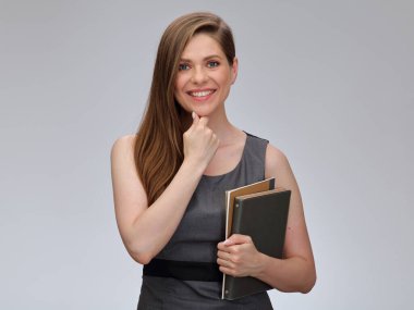 Gülümseyen öğretmen ya da gri iş elbiseli öğrenci kadın çenesine dokunuyor kitapla duruyor, izole edilmiş kadın portresi..