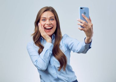 Şaşırtıcı, şaşkın bir kadın akıllı telefon kullanıyor ve yüzüne dokunuyor. izole edilmiş stüdyo resmi.