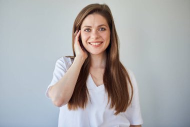 Yüzüne dokunan beyaz gömlekli, gülümseyen bir kadın. izole edilmiş resim.