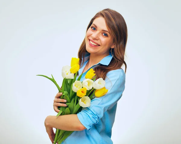 Happy woman holding yellow and white tulips. isolated female portrait in blue shirt.