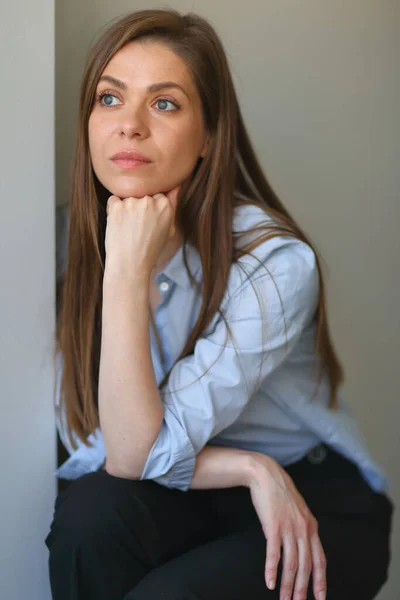 Woman sitting on chair resting, focused and thinking.