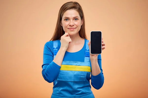 Usmívající Žena Montérkách Ukazující Obrazovku Smartphonu Izolovaný Portrét Pracovnice — Stock fotografie