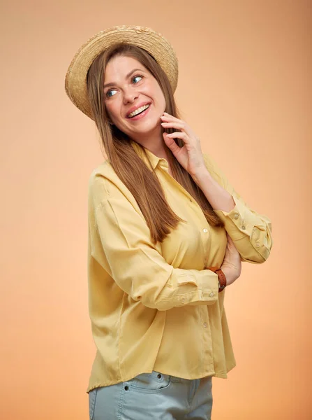 戴着夏帽微笑的女人回头望着 隔离在工作室黄色的背景门廊上 — 图库照片