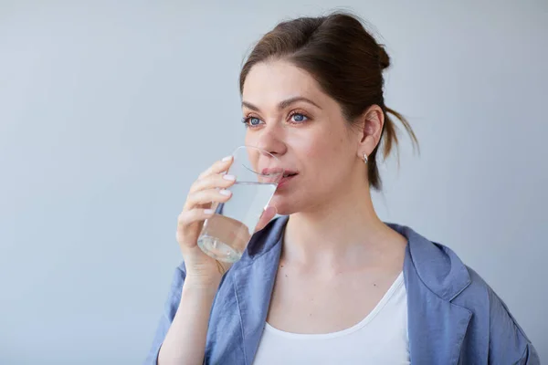 Woman drink water. Girl in casual clothes isolated portrait.
