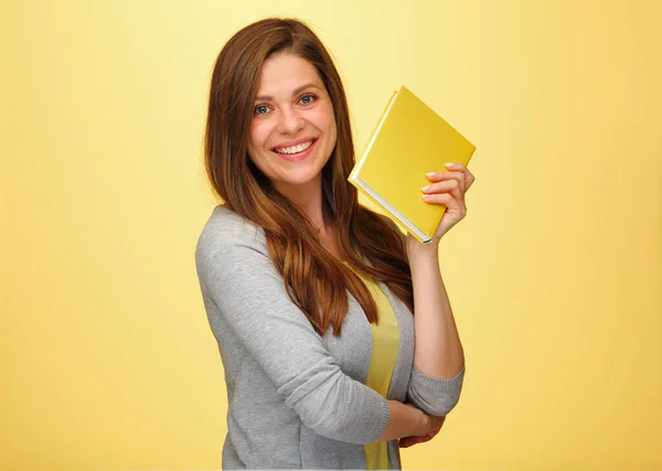 Smiling woman teacher holding books. isolated female portrait on yellow background. Smiling student girl with long hair.