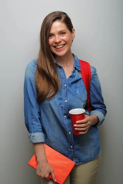 Woman student with red backpack, red book and big coffee glass. isolated female portrait.