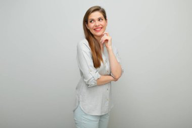 Düşünen kadın izole edilmiş portreye bakıyor, genç bayan pantolonlu ve gri gömlekli..