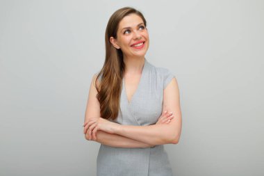 Kolları çapraz duran genç iş kadını, izole edilmiş, stüdyo resmi, gri elbiseli genç iş kadını..