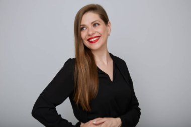 Gülümseyen kendine güvenen iş kadını ya da ofis çalışanı siyah takım elbiseli, el ele tutuşan ve uzaklara bakan, izole edilmiş kadın portresi..