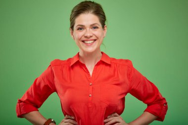 Kırmızı gömlekli gülümseyen genç bayan yeşil stüdyo arka planında izole edilmiş portre..