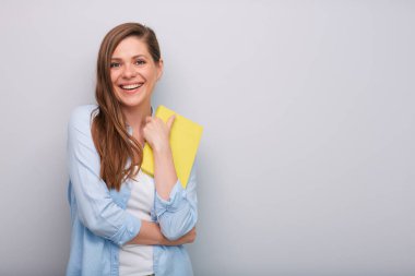 Gülümseyen kadın öğretmen ya da öğrenci kitap ya da çalışma kitabı münferit portre tutuyor  