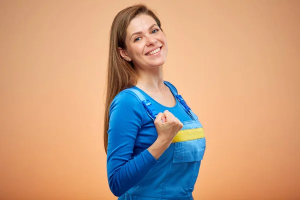 Hard industrial worker woman or student in blue overalls power gesture. Isolated female portrait.