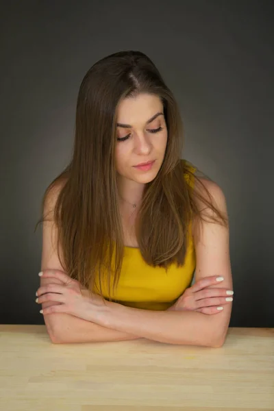 悲しみの女性のテーブルに座って見下ろしています 若い女性の自然な肖像画 — ストック写真