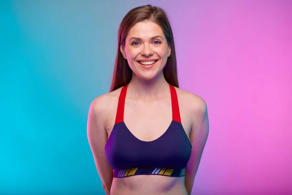 穿着健美胸罩的女运动员背着双手微笑 基于霓虹灯彩色背景的女性健身肖像 — 图库照片