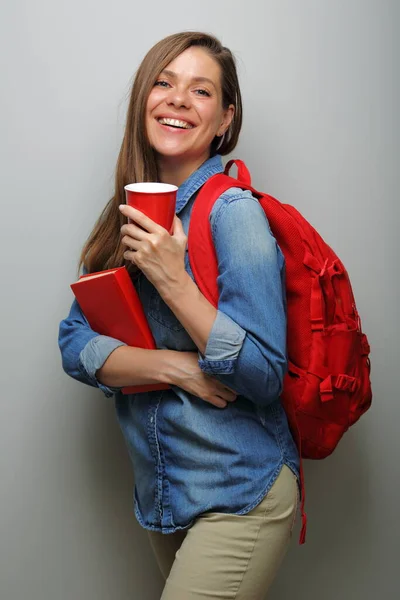 Woman student with red backpack, red book and big coffee glass. isolated female portrait.