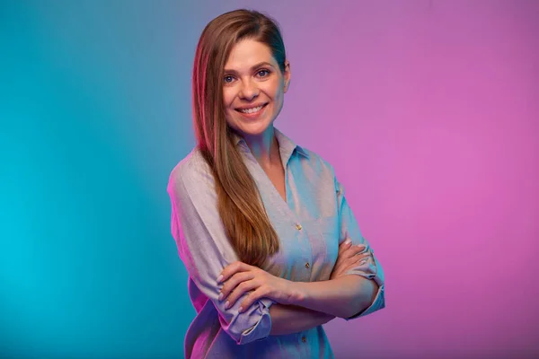 Happy business woman with arms crossed portrait in neon lights. Businesswoman isolated on neon multicolored background.