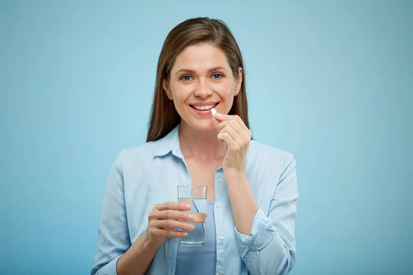 Glimlachende Vrouw Die Pil Eet Geïsoleerd Portret Blauwe Rug Waterglas — Stockfoto