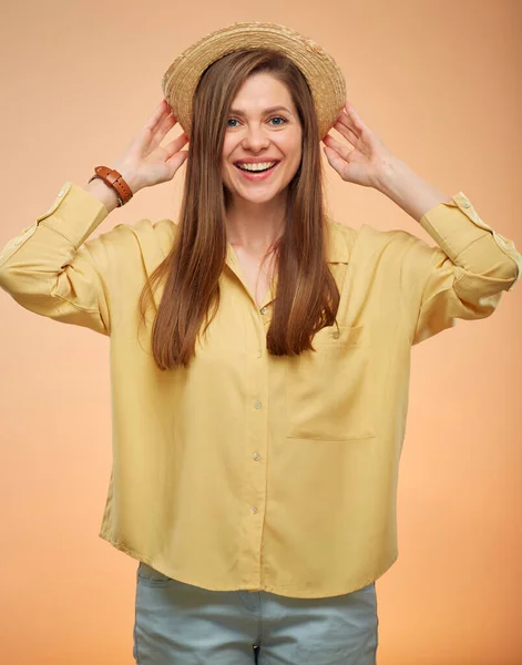 笑顔の女性黄色の背景に孤立した肖像画 彼女の帽子に触れる若い女性 — ストック写真
