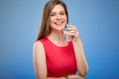 Kırmızı elbiseli, elinde su bardağı olan genç bayan mavi arka planda izole edilmiş bir portre..