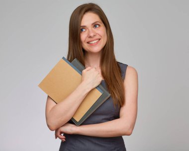 Uzun saçlı, iş elbisesi giymiş, elinde kitap tutan ve başka tarafa bakan bir bayan öğretmen. İzole edilmiş portre.